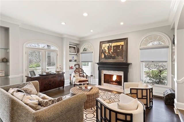 living area with dark wood-type flooring, ornamental molding, and a healthy amount of sunlight