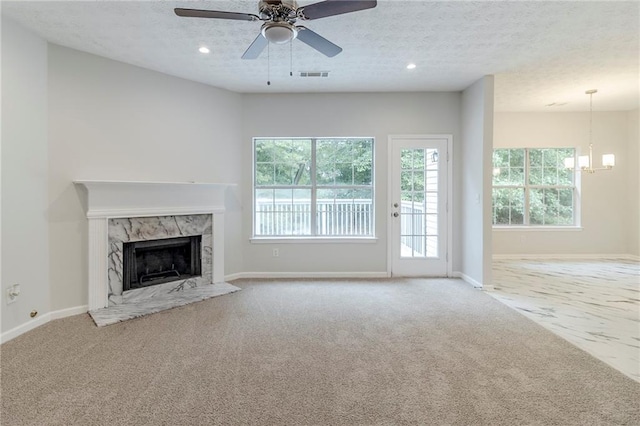 6118 Arbor Links Rd, Lithonia, GA 30058 - unfurnished living room featuring carpet flooring, a high end fireplace, a textured ceiling, a chandelier, and ceiling fan