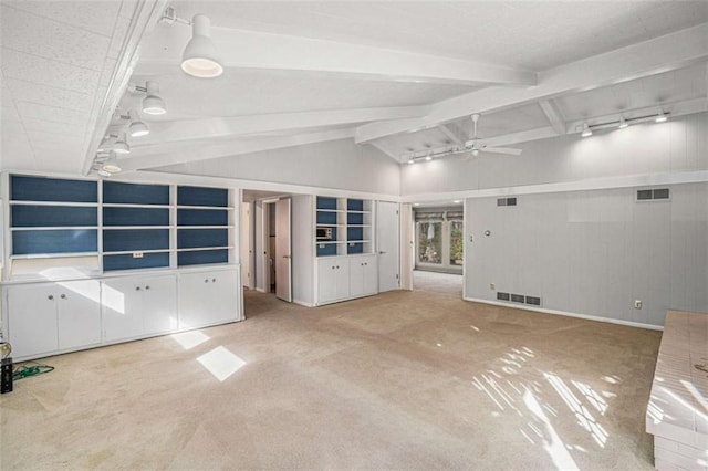 unfurnished living room with lofted ceiling with beams, rail lighting, carpet floors, and ceiling fan