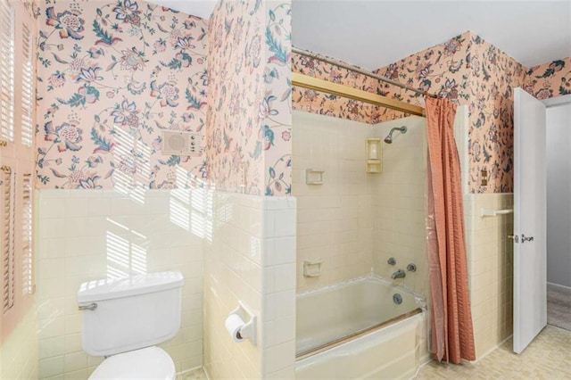 bathroom with shower / bath combo with shower curtain, toilet, and tile walls