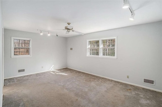 spare room with ceiling fan, a healthy amount of sunlight, carpet flooring, and rail lighting