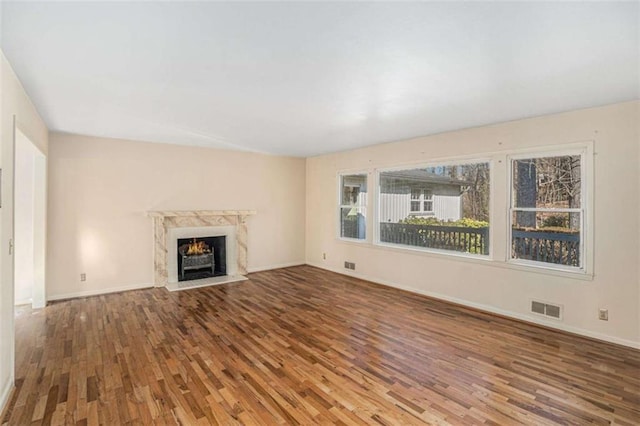 unfurnished living room featuring hardwood / wood-style flooring and a premium fireplace