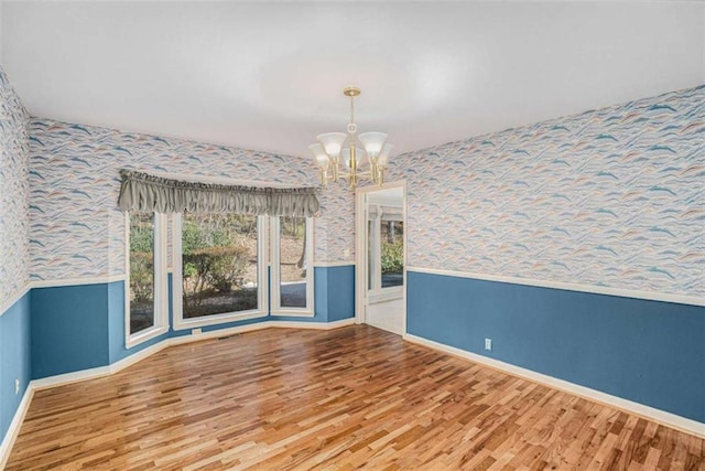 unfurnished dining area with wood-type flooring and a chandelier