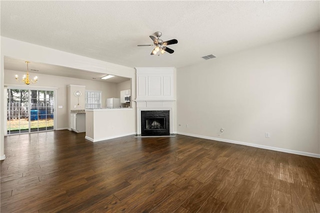 4100 Howell Park Rd, Duluth, GA 30096 - unfurnished living room featuring dark wood-style floors, a chandelier, ceiling fan, a fireplace, and a textured ceiling