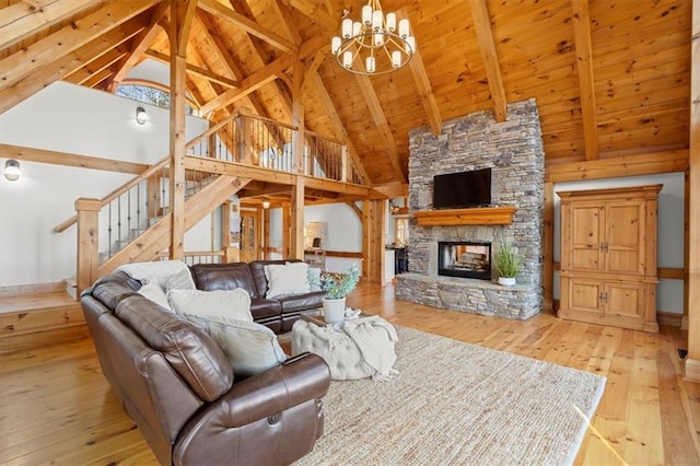 living area with wooden ceiling, a fireplace, stairs, light wood-type flooring, and beamed ceiling