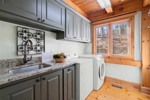 laundry room with a sink, visible vents, wood ceiling, independent washer and dryer, and cabinet space