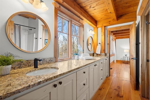 full bathroom with double vanity, wooden ceiling, hardwood / wood-style flooring, a sink, and beam ceiling