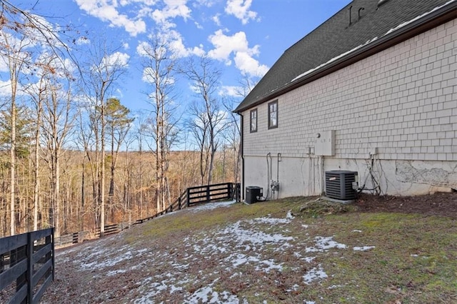 view of property exterior with fence and central air condition unit