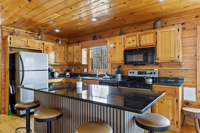 kitchen with appliances with stainless steel finishes, light wood-type flooring, dark countertops, a kitchen bar, and wood ceiling
