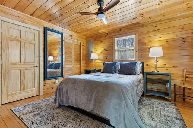 bedroom with wood ceiling, wooden walls, wood finished floors, and ceiling fan