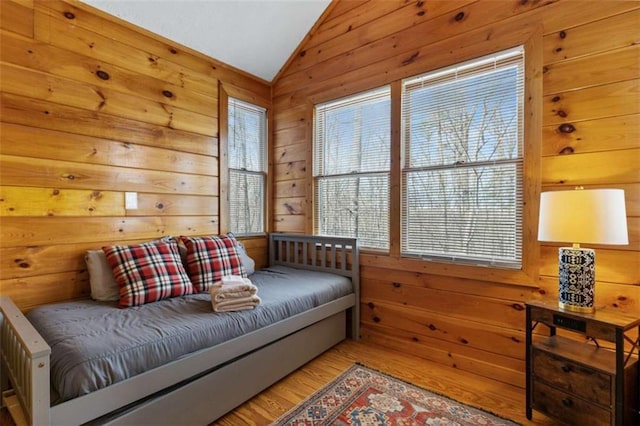 sitting room with lofted ceiling, wood finished floors, and wood walls