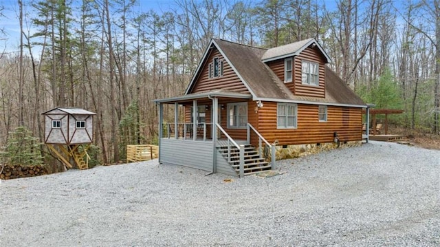 log-style house with covered porch and crawl space