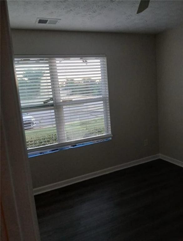 unfurnished room with ceiling fan, plenty of natural light, and dark hardwood / wood-style floors