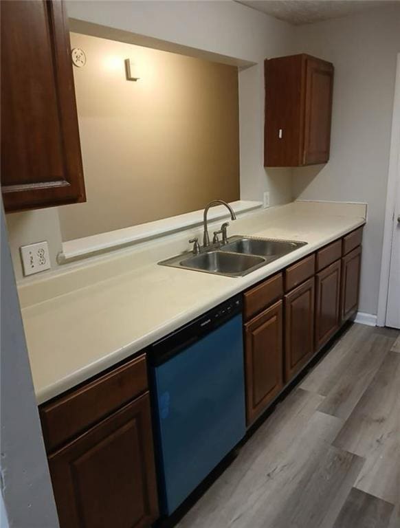 kitchen with dark brown cabinetry, dishwasher, sink, and light hardwood / wood-style floors