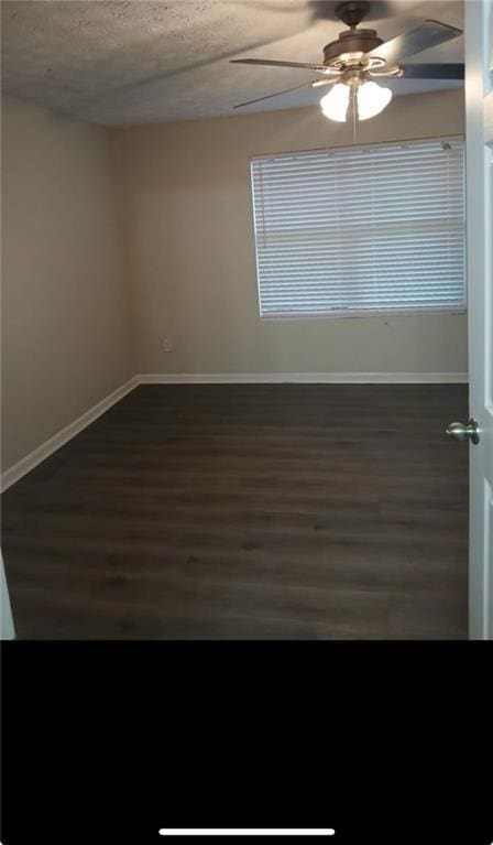 unfurnished room with a textured ceiling, ceiling fan, and dark hardwood / wood-style floors