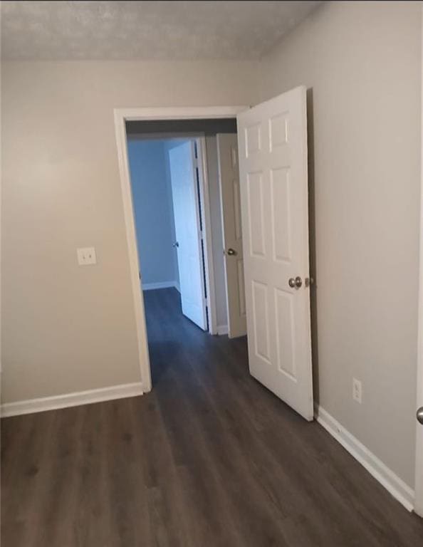 corridor with dark hardwood / wood-style floors