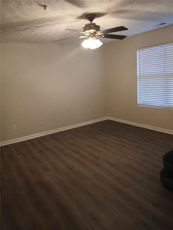 empty room with ceiling fan and dark hardwood / wood-style floors