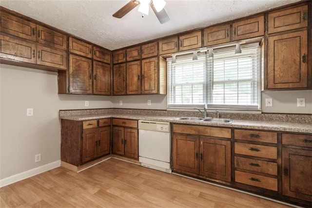 kitchen with white dishwasher, light hardwood / wood-style flooring, sink, ceiling fan, and a textured ceiling