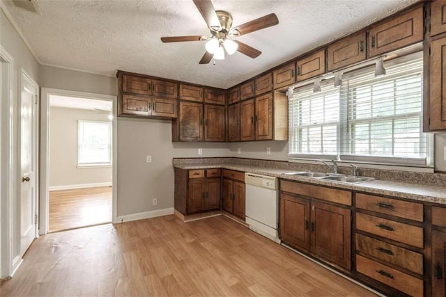 kitchen featuring dishwasher, light hardwood / wood-style floors, a wealth of natural light, ceiling fan, and a textured ceiling