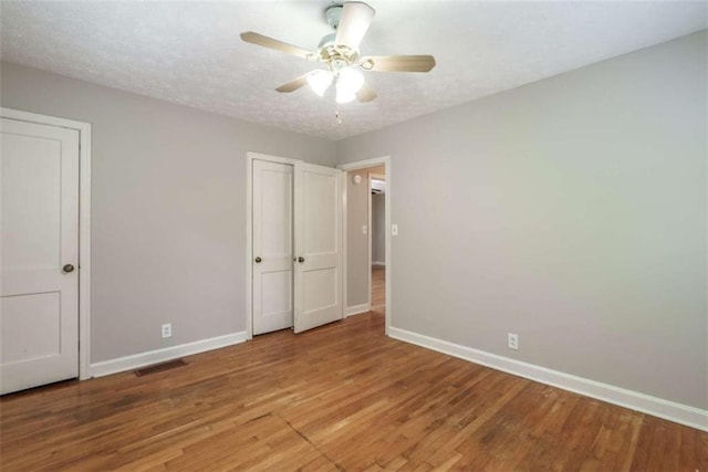 unfurnished bedroom featuring a textured ceiling, ceiling fan, and light hardwood / wood-style floors