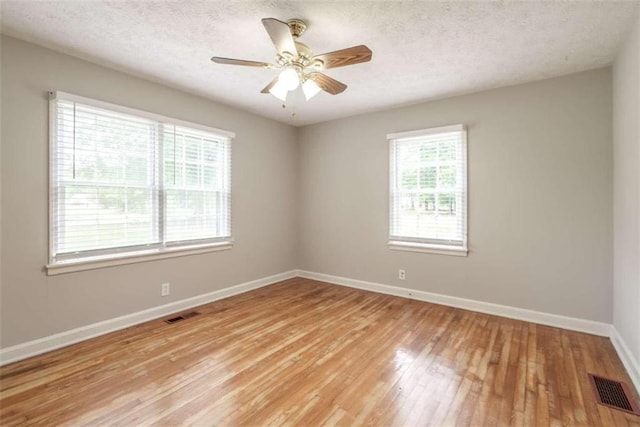 empty room featuring a textured ceiling, ceiling fan, and light hardwood / wood-style floors