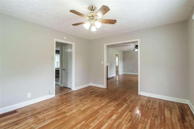 spare room featuring a textured ceiling, wood-type flooring, and ceiling fan