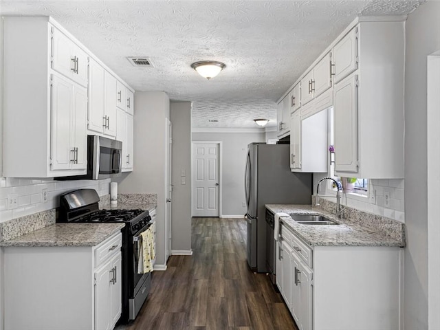 30 Court S, Ellenwood, GA 30294 - kitchen featuring appliances with stainless steel finishes, tasteful backsplash, white cabinetry, and a textured ceiling