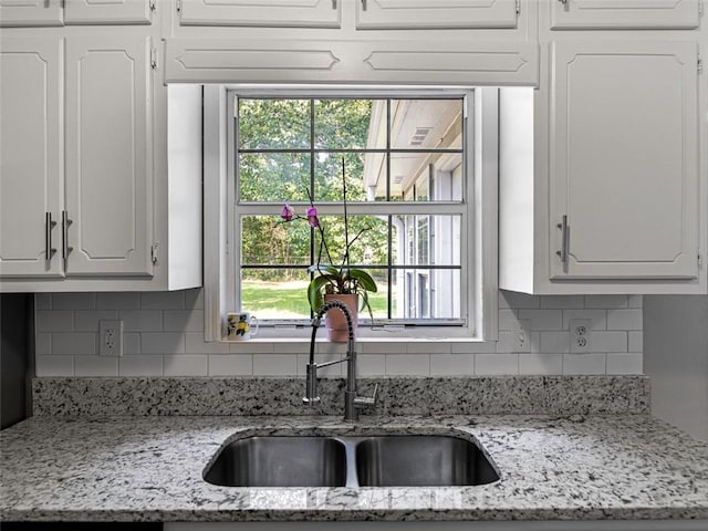 30 Court S, Ellenwood, GA 30294 - kitchen featuring white cabinetry, tasteful backsplash, and healthy amount of natural light