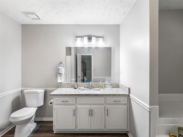 30 Court S, Ellenwood, GA 30294 - full bathroom featuring vanity, wood finished floors, a bath, and a textured ceiling