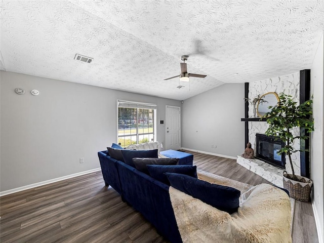 30 Court S, Ellenwood, GA 30294 - living area with dark wood-style flooring, ceiling fan, a stone fireplace, a textured ceiling, and lofted ceiling