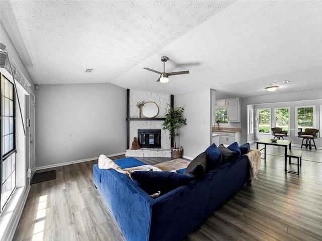 30 Court S, Ellenwood, GA 30294 - living area featuring wood finished floors, a fireplace, a textured ceiling, a ceiling fan, and vaulted ceiling