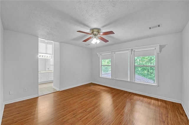 4440 Coventry Ct NE, Roswell, GA 30075 - spare room with a ceiling fan, baseboards, wood finished floors, and a textured ceiling