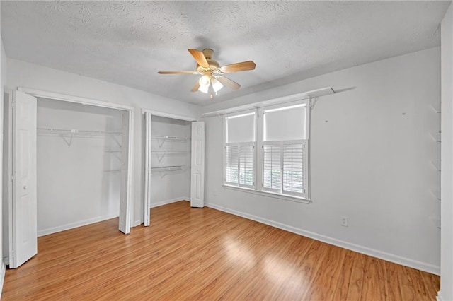 4440 Coventry Ct NE, Roswell, GA 30075 - unfurnished bedroom featuring multiple closets, light wood finished floors, baseboards, a textured ceiling, and a ceiling fan