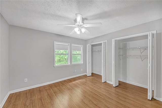 4440 Coventry Ct NE, Roswell, GA 30075 - unfurnished bedroom with multiple closets, wood finished floors, baseboards, a textured ceiling, and ceiling fan