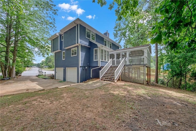 4440 Coventry Ct NE, Roswell, GA 30075 - rear view of property featuring a sunroom, a chimney, a garage, stairway, and concrete driveway