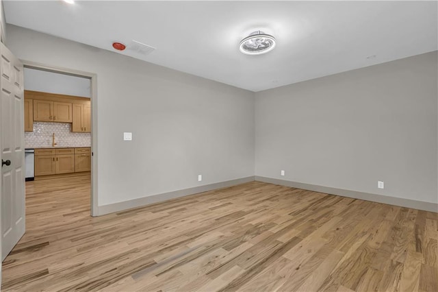 unfurnished room with light wood-type flooring and sink