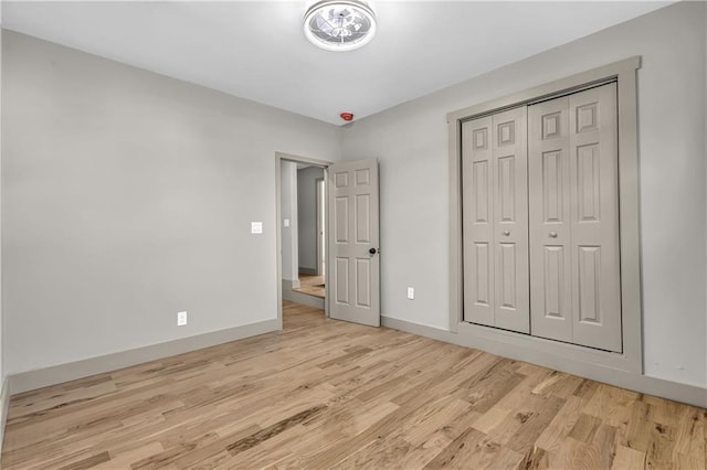 unfurnished bedroom with light hardwood / wood-style flooring and a closet