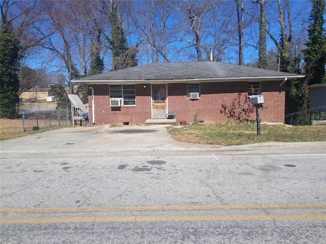 view of front of house with cooling unit, brick siding, and roof with shingles