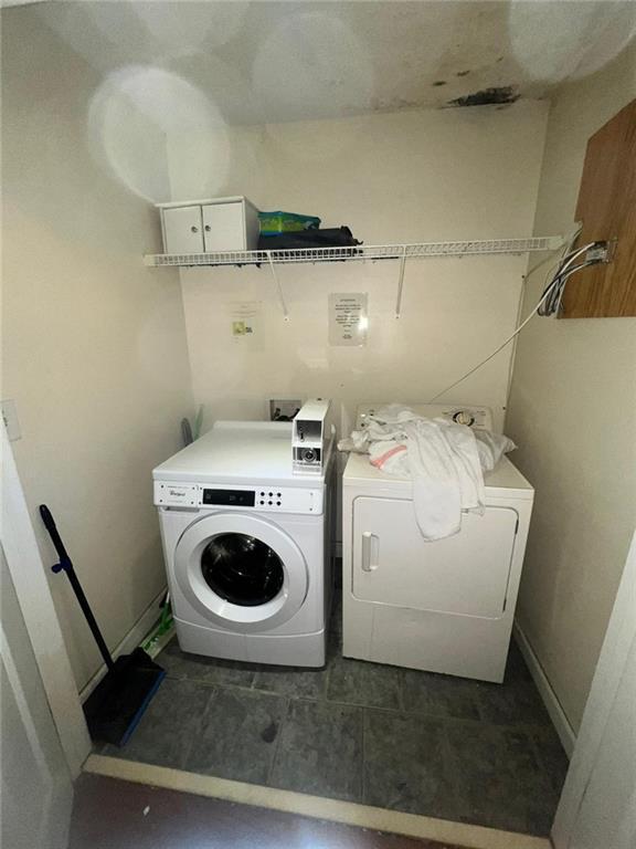 laundry area with independent washer and dryer and dark tile floors