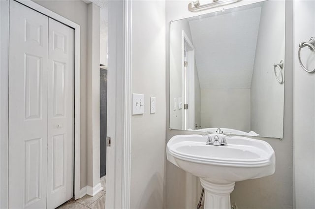 bathroom with vaulted ceiling and tile patterned floors