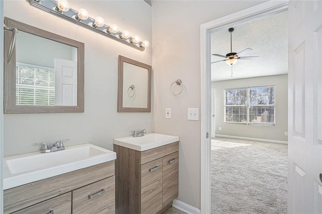 bathroom with a textured ceiling, ceiling fan, and vanity