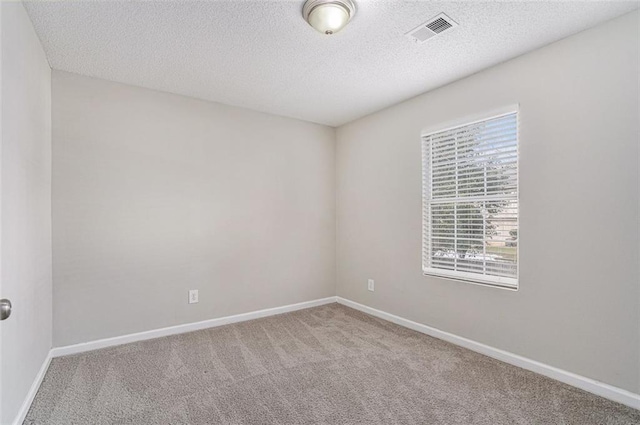 unfurnished room with a textured ceiling and carpet floors