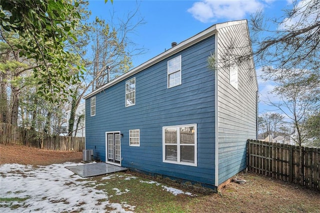 snow covered house featuring central air condition unit