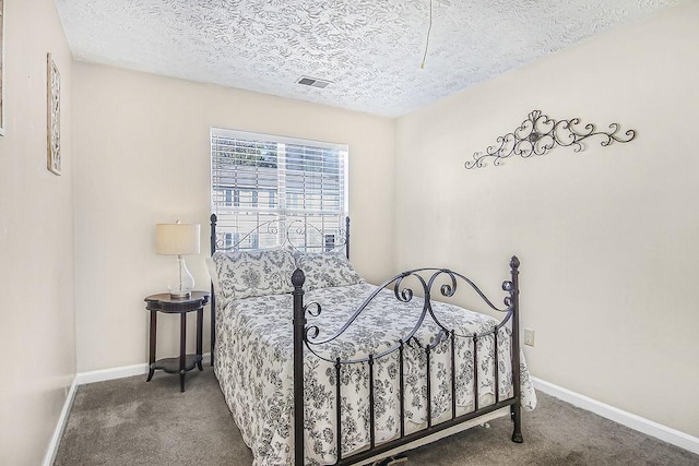 bedroom with carpet floors and a textured ceiling