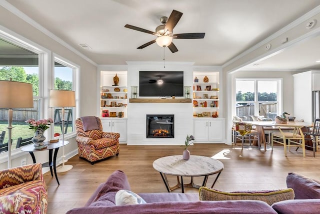 259 Dunagan Ct, Winder, GA 30680 - living area with wood finished floors, ornamental molding, ceiling fan, a large fireplace, and built in features