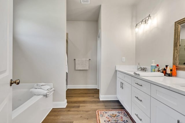 259 Dunagan Ct, Winder, GA 30680 - bathroom with wood finished floors, a bath, and double vanity