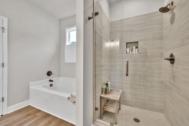 259 Dunagan Ct, Winder, GA 30680 - bathroom featuring a shower stall, a bath, and wood finished floors