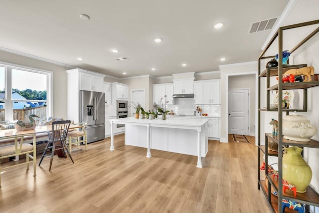 259 Dunagan Ct, Winder, GA 30680 - kitchen with stainless steel appliances, crown molding, light countertops, white cabinets, and backsplash