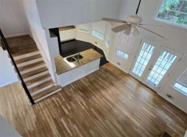 unfurnished living room featuring a ceiling fan and dark wood-style floors