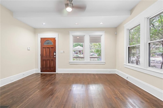 foyer entrance with ceiling fan and dark wood-type flooring